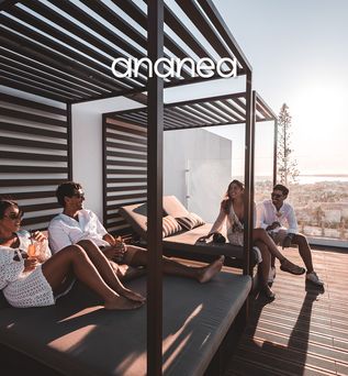 Eine Gruppe von Freunden auf Sitzgelegenheiten einer stylischen Hotel-Dachterrasse