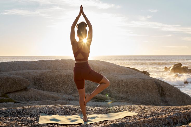 Frau macht Yoga am Strand
