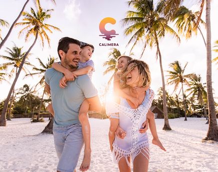 Familie mit zwei Kindern laeuft fröhlich an einem Strand entlang