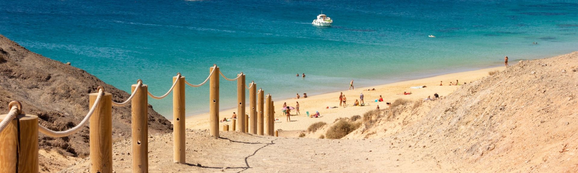Blick auf Strand und Bucht mit Booten auf Lanzarote, Kanarische Inseln, Spanien