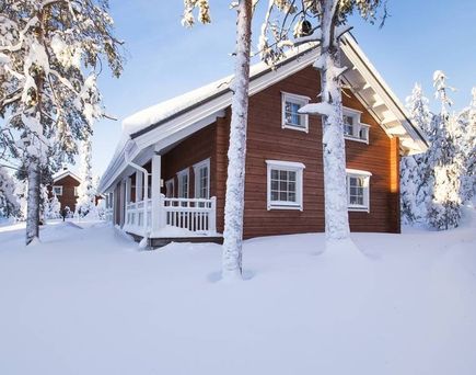 Eine Holzhütte in einer verschneiten Landschaft in Lappland, Finnland.