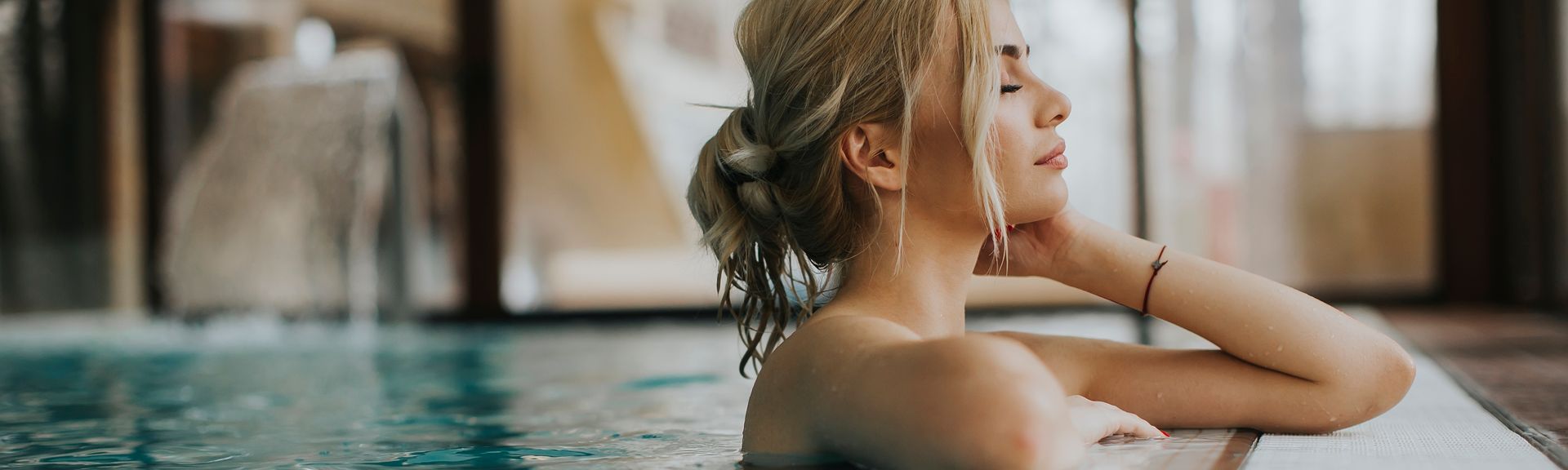 Frau entspannt mit geschlossenen Augen in einem Spa-Bereich eines Hotels