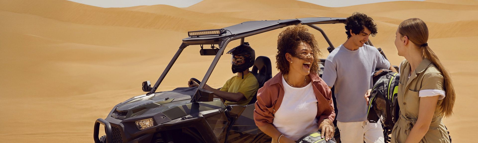 Eine Gruppe fröhlicher Gäste bei einer Wüstentour vor den Toren Abu Dhabis.